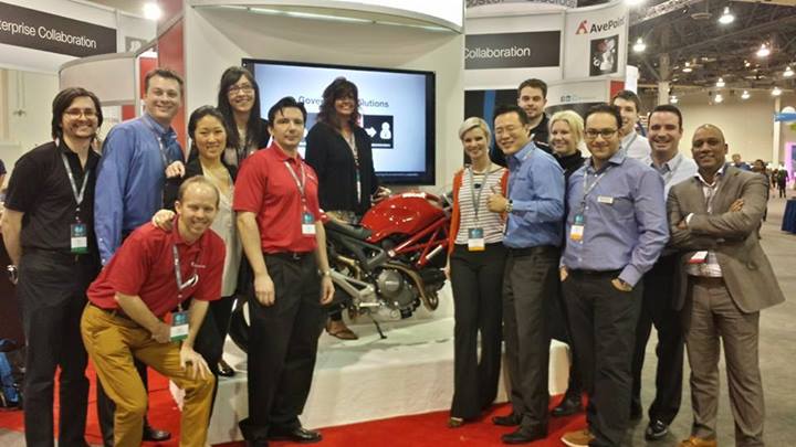 Ducati winner posing with her new Ducati Monster 696 and members of the AvePoint team.